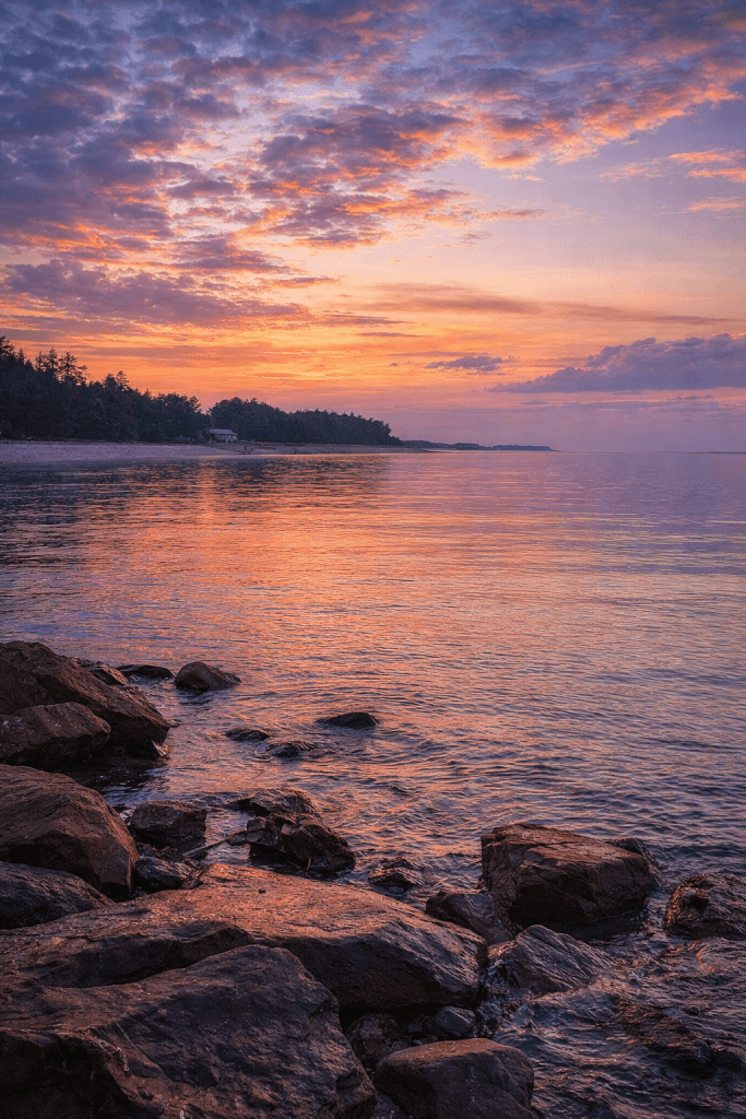 Peaceful sunrise view at Put-in-Bay Ohio with calm Lake Erie water and rocky shoreline